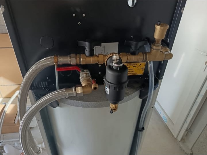 Raccordements visibles sous un chauffe-eau